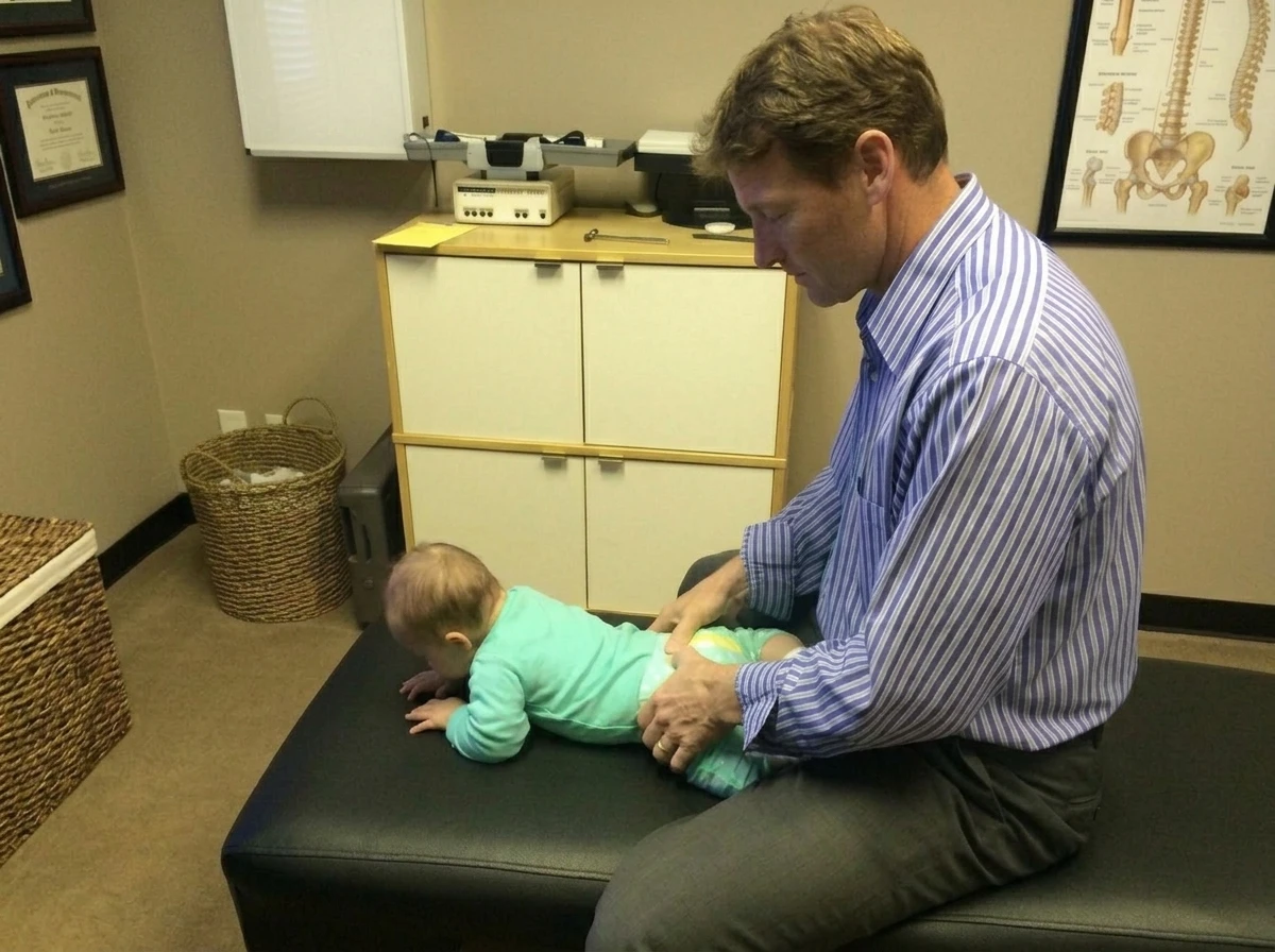 Chiropractor Examining Infant on Treatment Table go green light chiropractic image